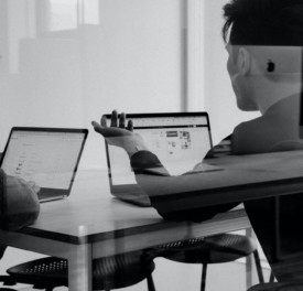 black and white photo of two men on laptops in an office